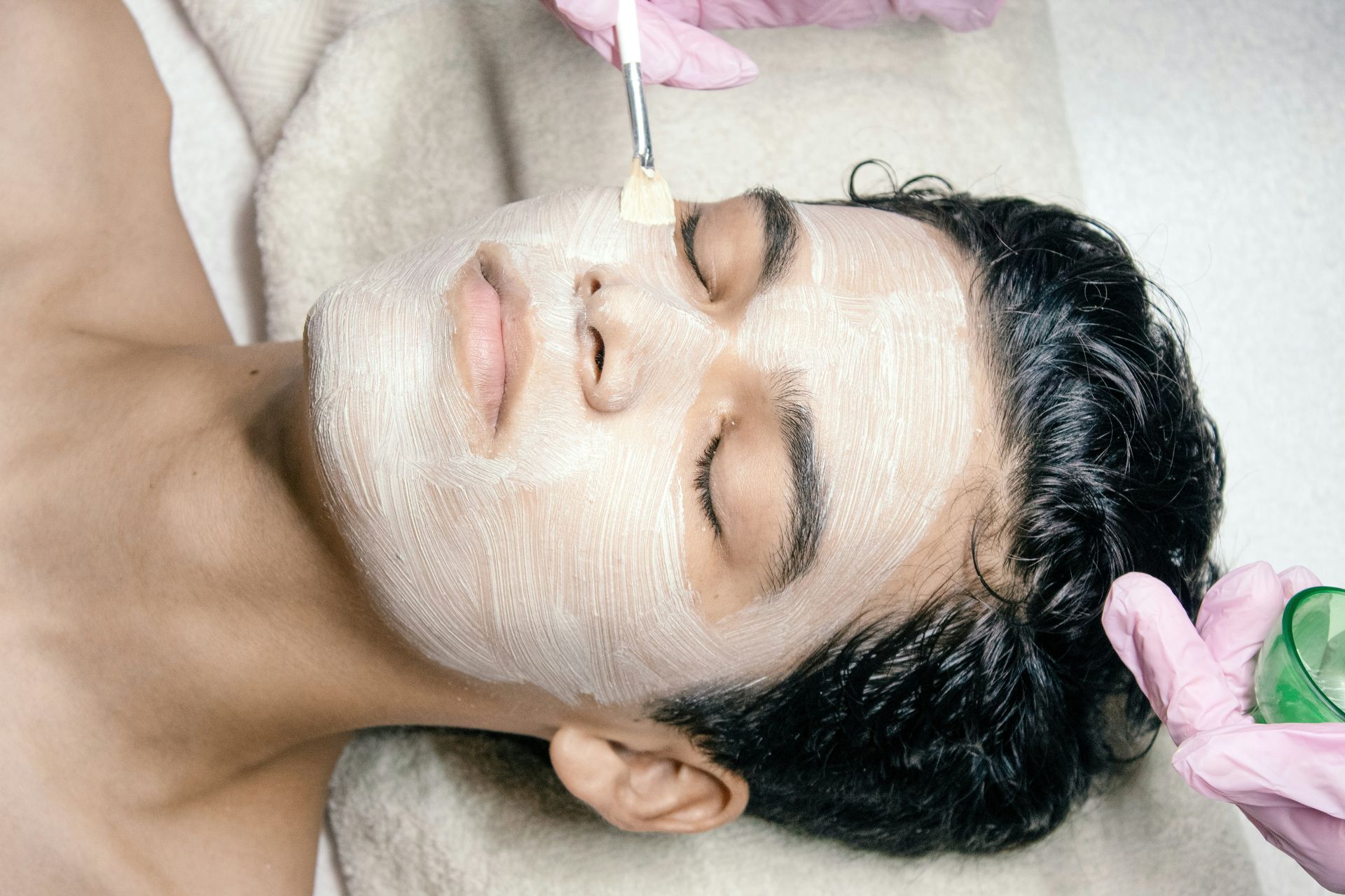 A man getting a facial mask on his face