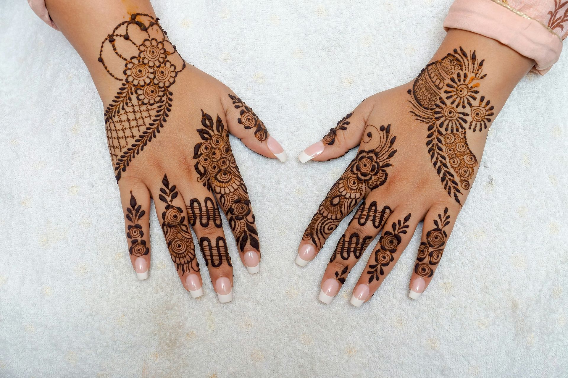 A woman's hands with henna tattoos on them